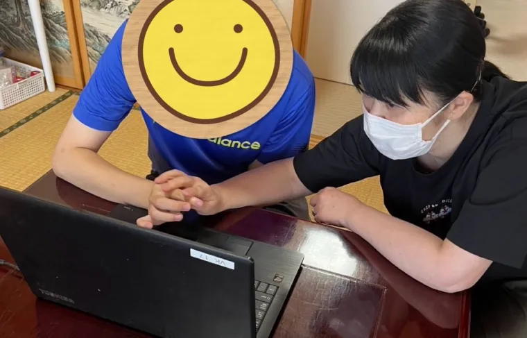 職員と一緒にパソコン操作を練習する様子